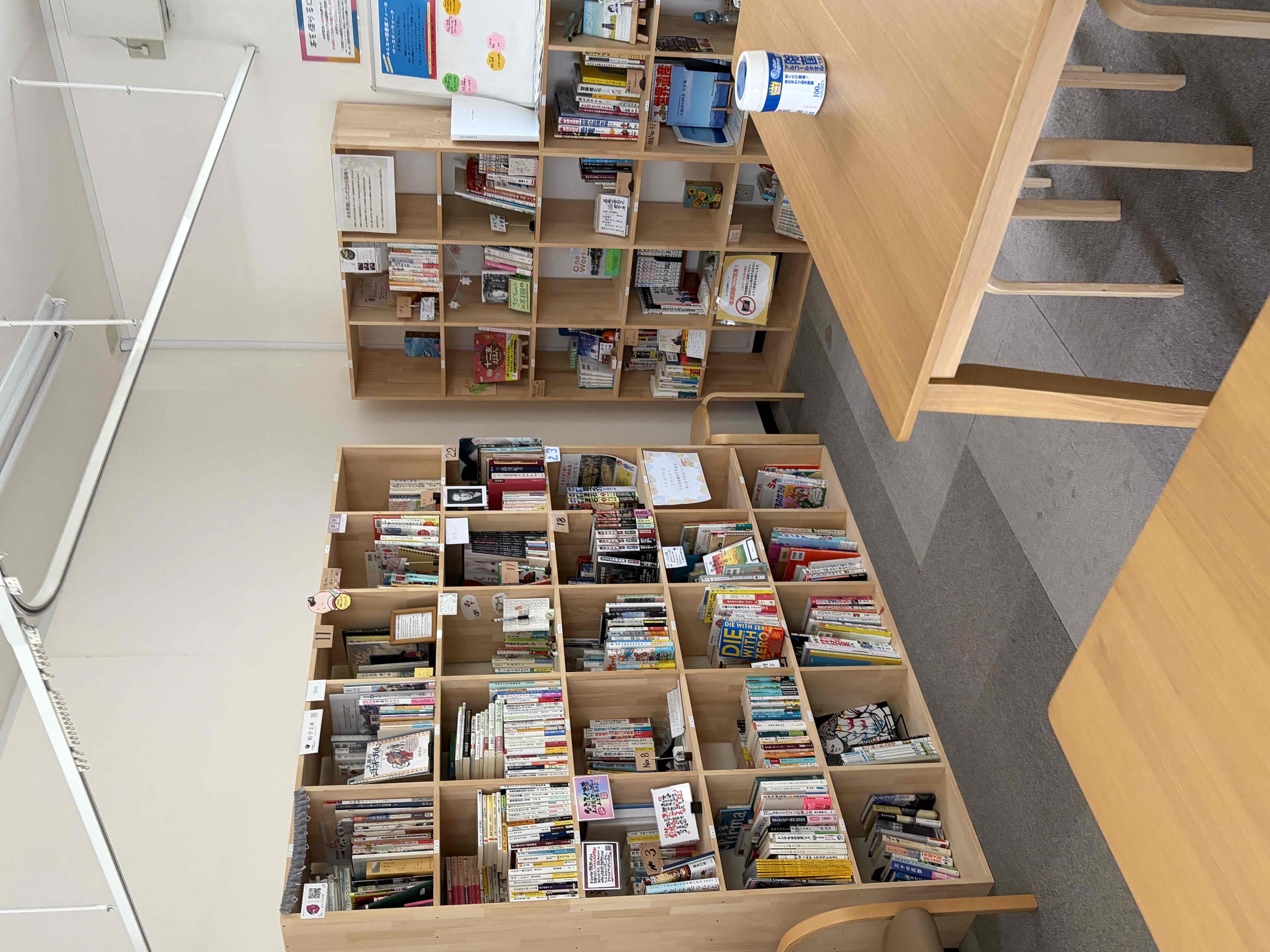 みんなの図書館フィーカの実際の店内写真。木製の棚とテーブルが並ぶ温かみのある空間